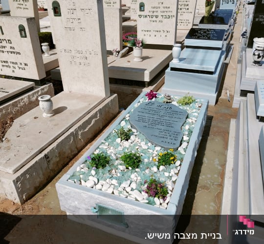 מצבות בבית קברות עם פרחים ואבנים